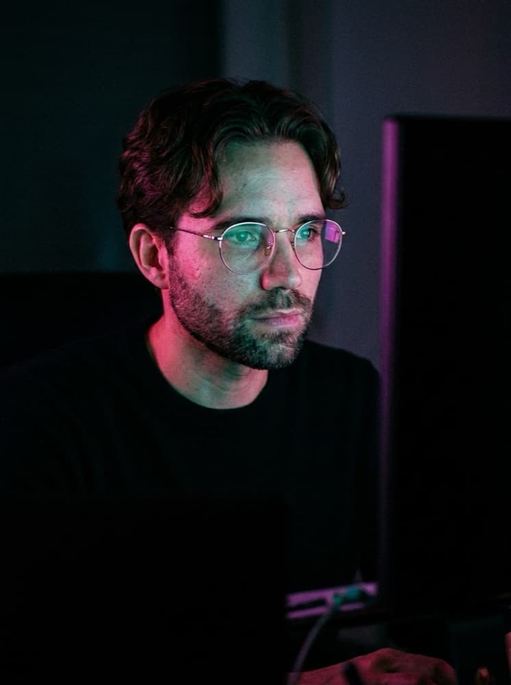 Johnny Unar working, lit by monitor glow